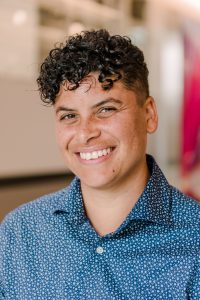 Image of Chris Hawn, smiling nonbinary Black person with short curly hair